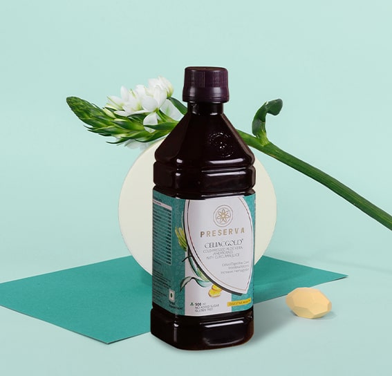 Celiacgold Juice in front of the round white object and a flower on the object.