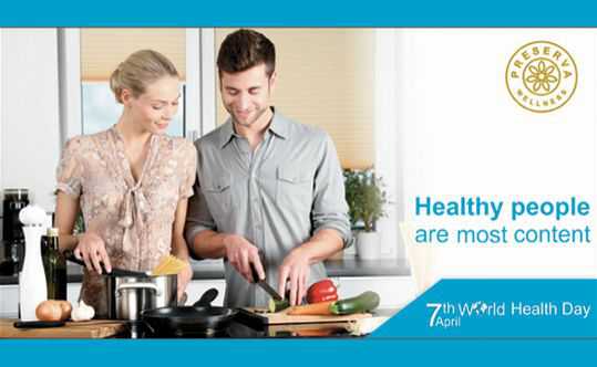 Two people making healthy food in the kitchen. Text written- Healthy people are most content (World Health Day)