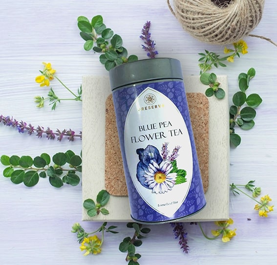 Blue Pea Flower Tea on an off-white square stone with lavenders and chamomile around it.