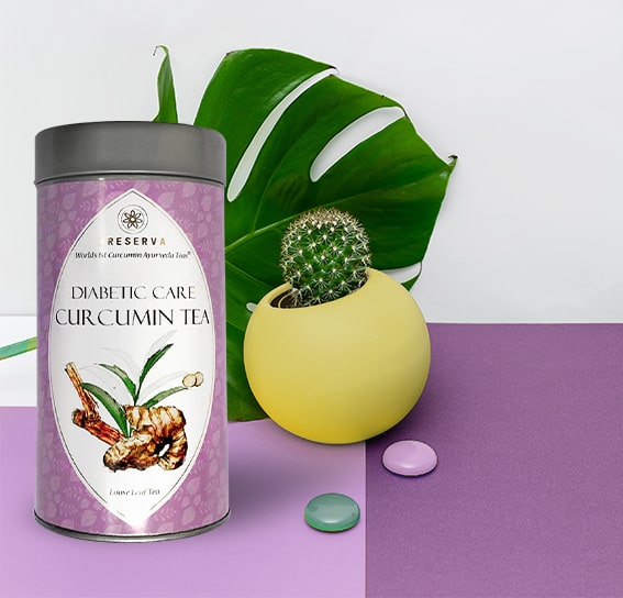 Diabetic Care Curcumin Tea Box next to a Cactus in a yellow pot with two gems on a purple shade table.