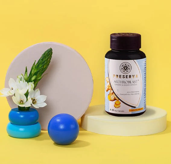 Arthroblast Capsules on a round shade stand next to a blue colour ball and a flower pot with white flowers.